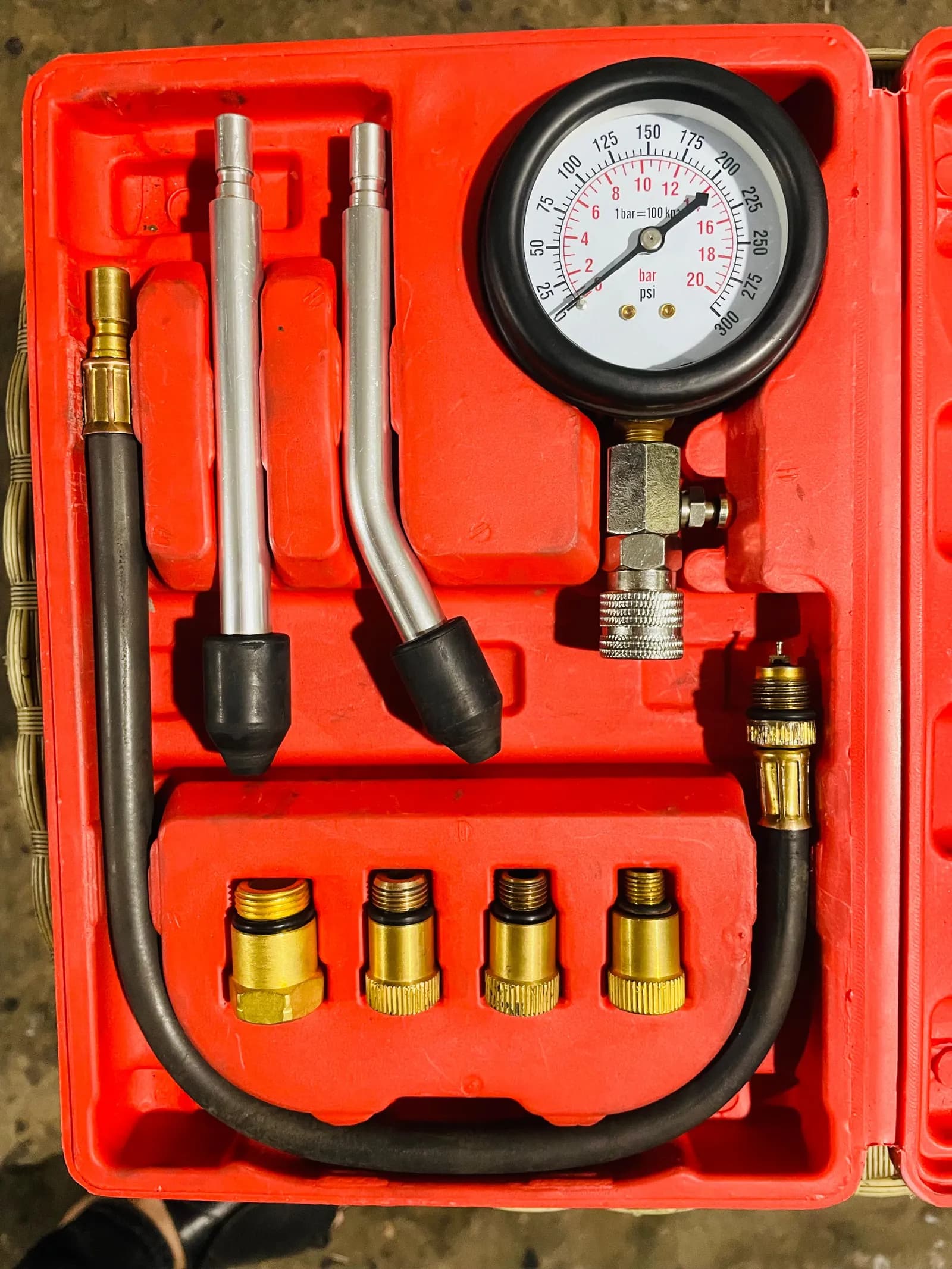 Engine compression test gauge kit with adapters in its red case