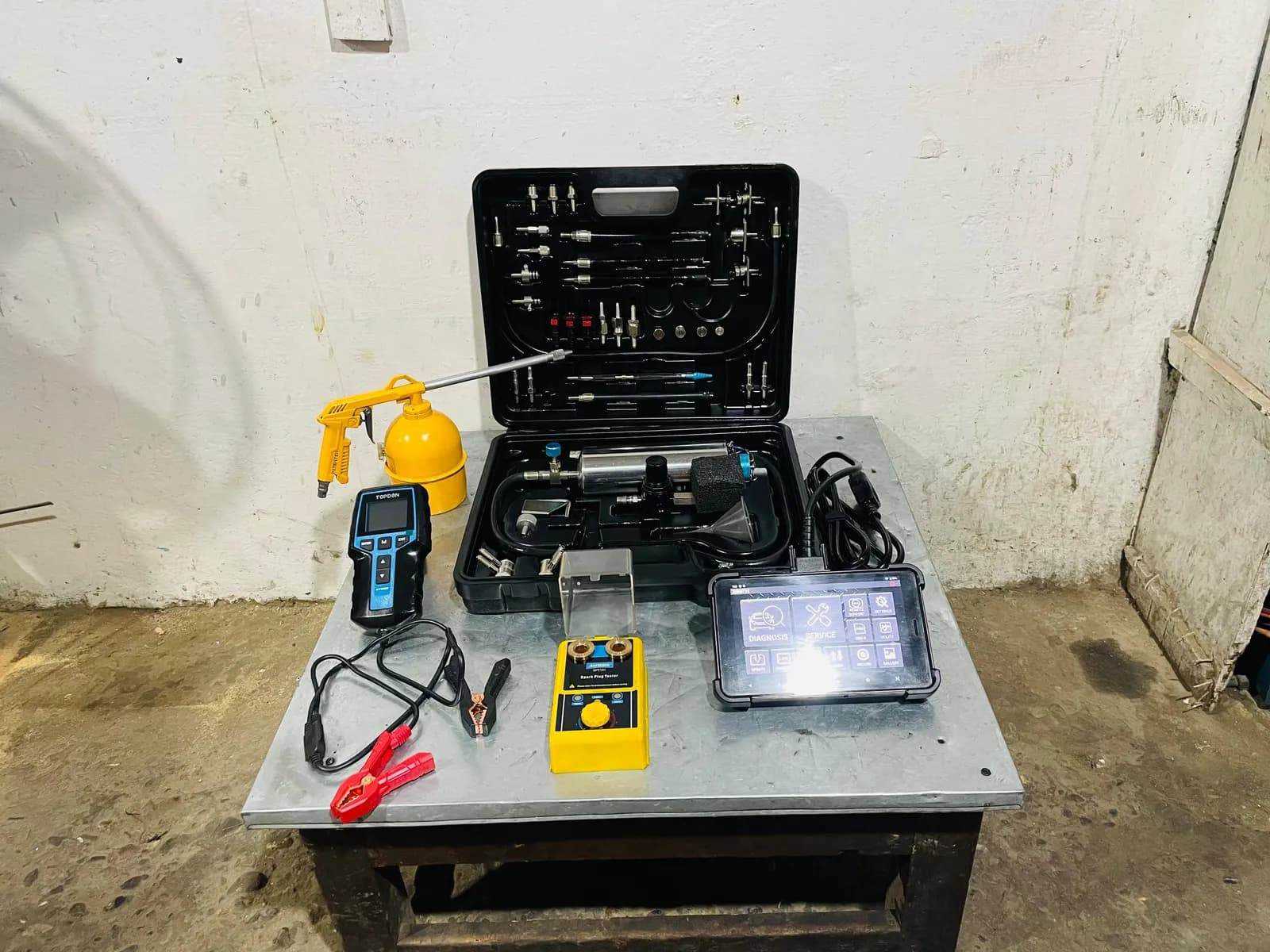 EFI diagnostic kit with a scan tablet, multimeter and fuel-pressure test set on a workbench