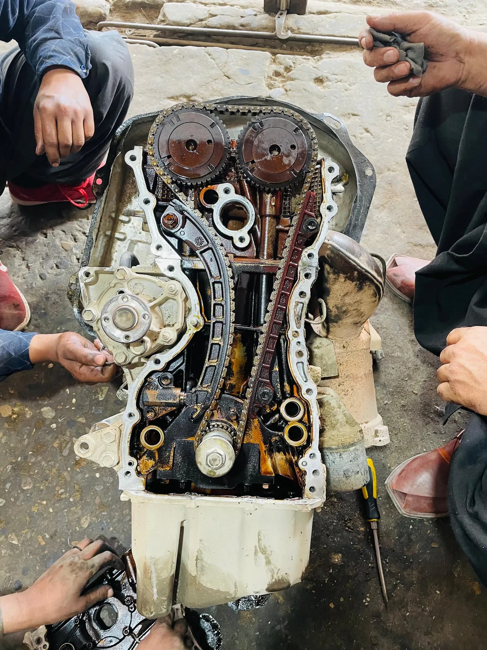Engine with the timing cover removed, showing the timing chain, cam gears and valve train during an EFI engine repair