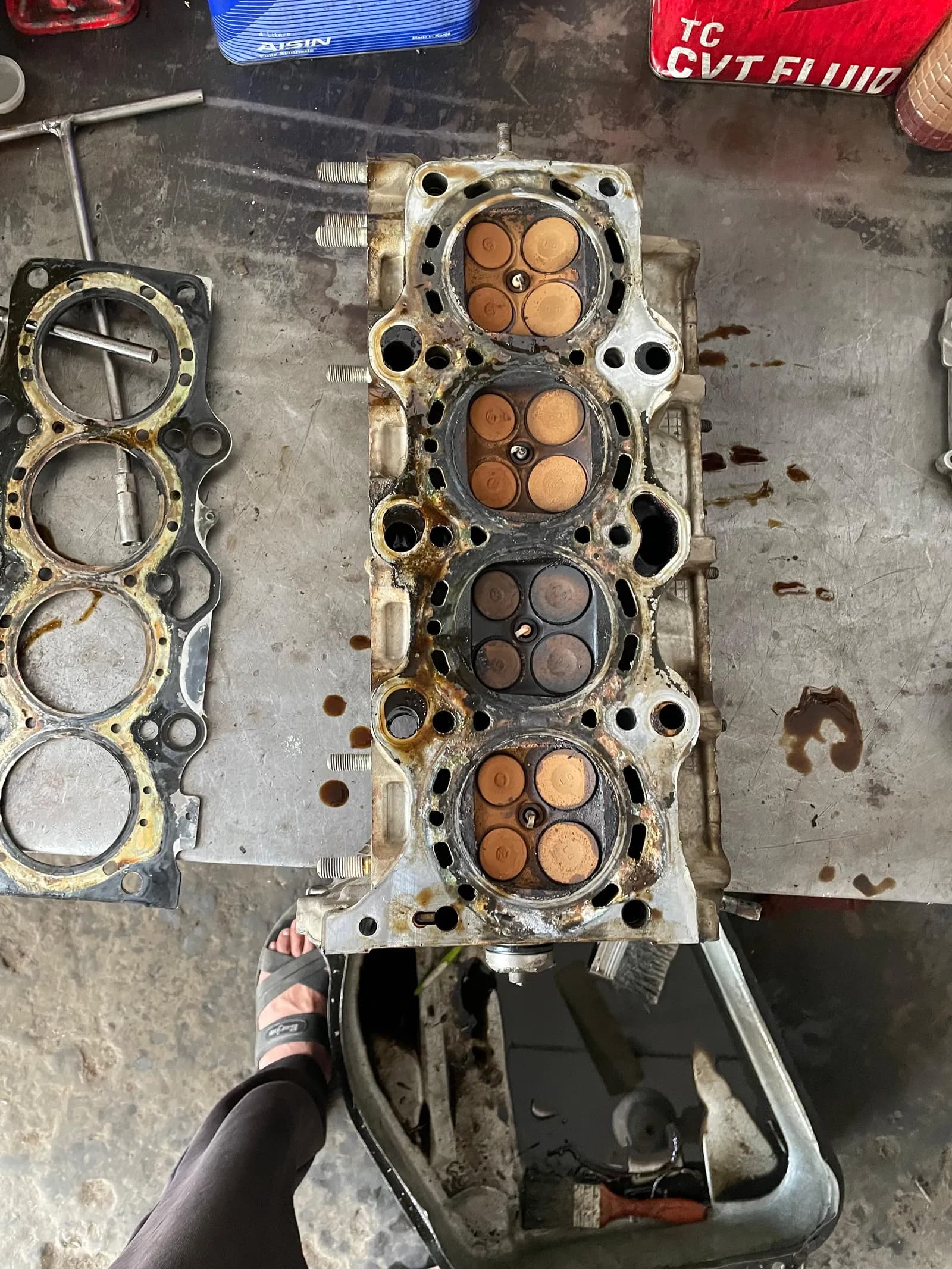 Engine block with the cylinder head removed, showing carbon on the pistons, during a head gasket replacement