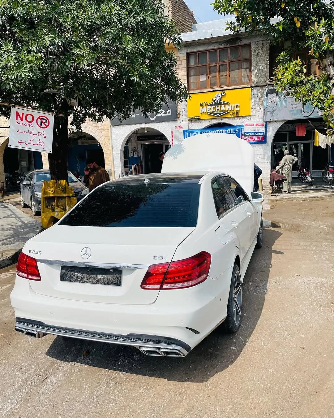 A white Mercedes-Benz parked outside the My Mechanic workshop