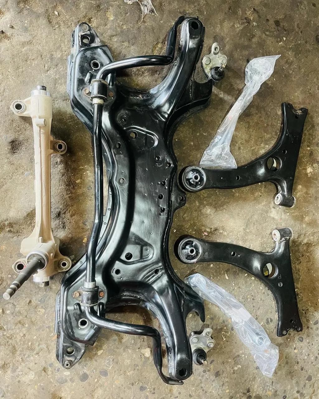 Front suspension subframe with new control arms and bushes laid out for a complete suspension rebuild