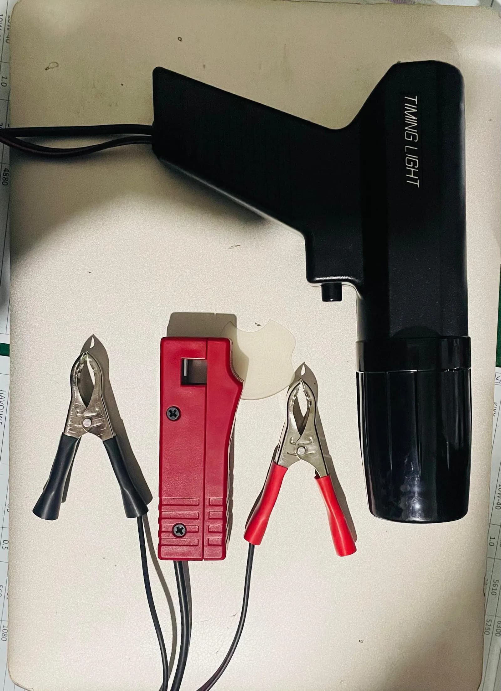 Inductive ignition timing light with its clamps, used for engine tuning